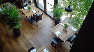 modern restaurant interior featuring wooden floors, potted plants, and neatly arranged tables. bright atmosphere is enhanced by large windows allowing natural light to fill space photo