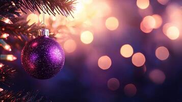 beautiful purple Christmas ornament hangs from tree branch, surrounded by soft, glowing lights that create warm and festive atmosphere. bokeh effect adds magical touch to scene photo
