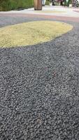 Black asphalt. Pebble stone flooring with epoxy resin in city park. Pebble stone is yellow and red. photo