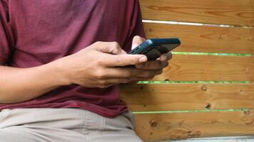A man sits and types a message using a hand phone or smart phone. Social life in the age of technology. photo
