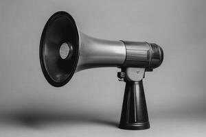 A Black and Silver Handheld Megaphone on a Grey Background photo