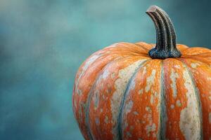 Close-up of a Striped Orange Pumpkin with a Blue Background photo