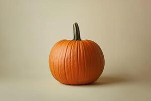 A Single Orange Pumpkin on a Light Tan Background photo