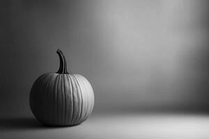 A Single, Gray-Scale Pumpkin on a Smooth, Gray Surface photo