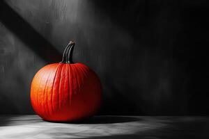A Single, Vibrant Orange Pumpkin Rests on a Dark, Textured Surface photo