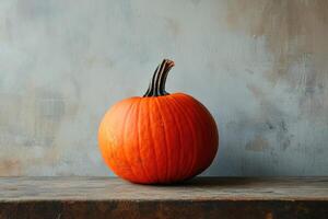 A Single Orange Pumpkin Resting on a Weathered Wooden Plank photo