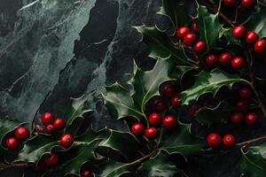 Red Berries and Green Holly Leaves on a Dark Slate Background photo