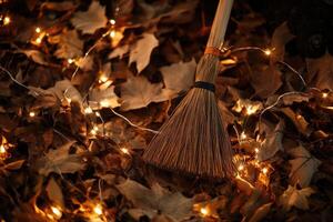 A Broom Resting Among Autumn Leaves and Fairy Lights photo