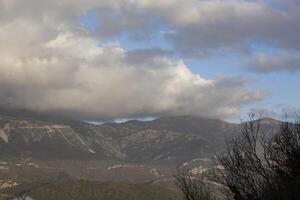 Winter in the mountains, beautiful mountain landscape. View of a mountain ridge and bare trees. Landscape in haze and cliffs. Budva, Montenegro. Europe. Background. For text. Banner. Postcard. photo