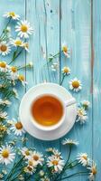 Cup of chamomile tea with fresh flowers on rustic blue wooden background, relaxing and wellness vibe photo