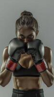 Confident female boxer with black gloves in strong stance, showing power, fitness, and determination photo