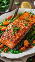 Grilled salmon with asparagus, peas, carrots, on a white platter. Healthy food. Restaurant menu photo