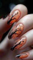 Close-up of Halloween orange nails with black tree silhouettes. Spooky and elegant manicure design photo