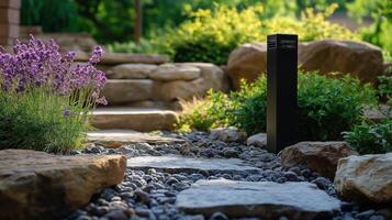 LED outdoor light post illuminating a garden path with flowering plants and decorative stones photo