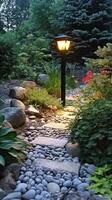 LED outdoor light post illuminating a garden path with flowering plants and decorative stones photo
