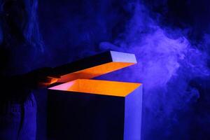 Man opens magic box with surprise on dark background, mystical box, surprise, halloween photo