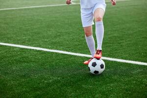 And the soccer player in the uniform and red clothes controlling the soccer ball on the Green Field photo