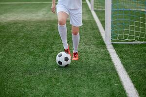 And the soccer player in the uniform and red clothes controlling the soccer ball on the Green Field photo