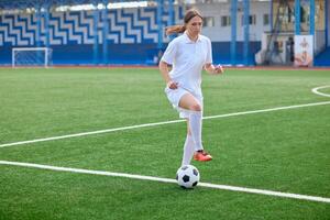 And the soccer player in the uniform and red clothes controlling the soccer ball on the Green Field photo