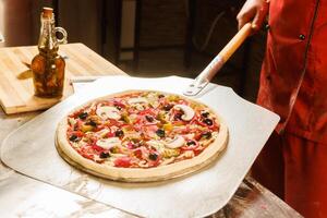 Chef preparing to bake a pizza photo