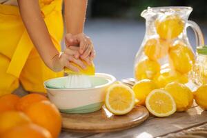 A pitcher of lemonade with sliced lemons and oranges on a table photo