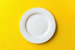 Empty white plate on yellow background photo