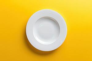Empty white plate on yellow background photo