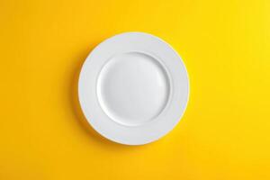Empty white plate on yellow background photo
