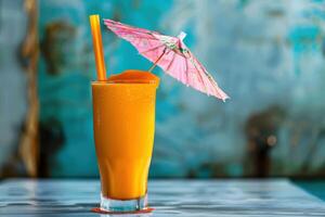 A glass of orange juice with a pink umbrella photo