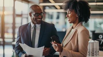 Two business people talking and smiling in an office photo