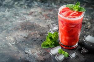 A glass of watermelon juice with mint leaves photo
