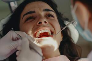 A woman is getting her teeth checked by a dentist photo