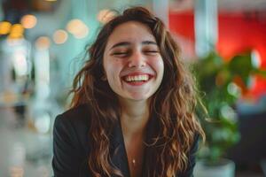A woman laughing while sitting in an office photo
