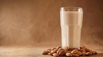 Almond milk in a glass with nuts on a brown background photo