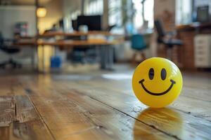 A smiley face balloon sitting on a wooden floor photo