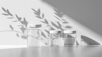 Three empty glass bottles with leaves on a white surface photo