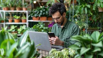 Man using laptop in a greenhouse photo