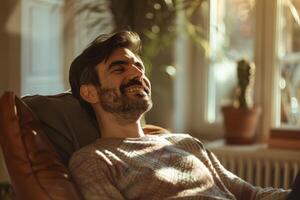 A man is smiling while sitting in a chair photo