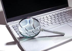 SEO search concept with magnifying glass on a website. Web research and engine optimization in a photo