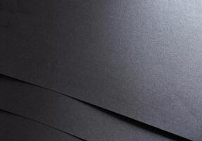 Black paper with a smooth texture and minimalist, geometric pattern. The monochrome design features photo