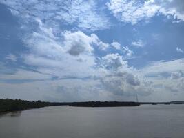 A large body of water with a few clouds in the sky photo