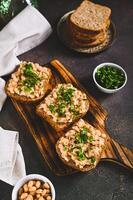 Bruschetta with mashed white beans and parsley on rye bread on a board vertical view photo