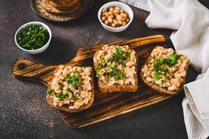 Bruschetta with mashed white beans and parsley on rye bread on a board photo