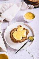 Delicious toasts with honey butter on a plate on the table vertical view photo