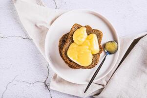 Close up of sandwiches on grain bread with honey butter on a plate on the table top view photo