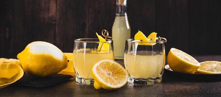Traditional homemade limoncello in glasses on the table web banner photo