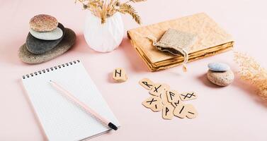 Scandinavian runes, notebook and pencil for writing on pink background web banner photo