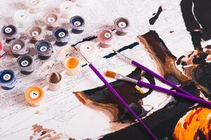 Set of multi-colored acrylic paints, brushes and canvas for painting by numbers photo