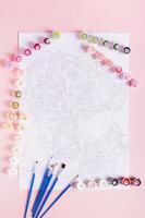 Painting by numbers kit and paper with diagram on pink background top and vertical view photo