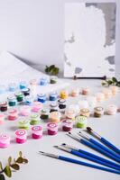 Painting by numbers kit, paints, brushes and paper on table vertical view photo